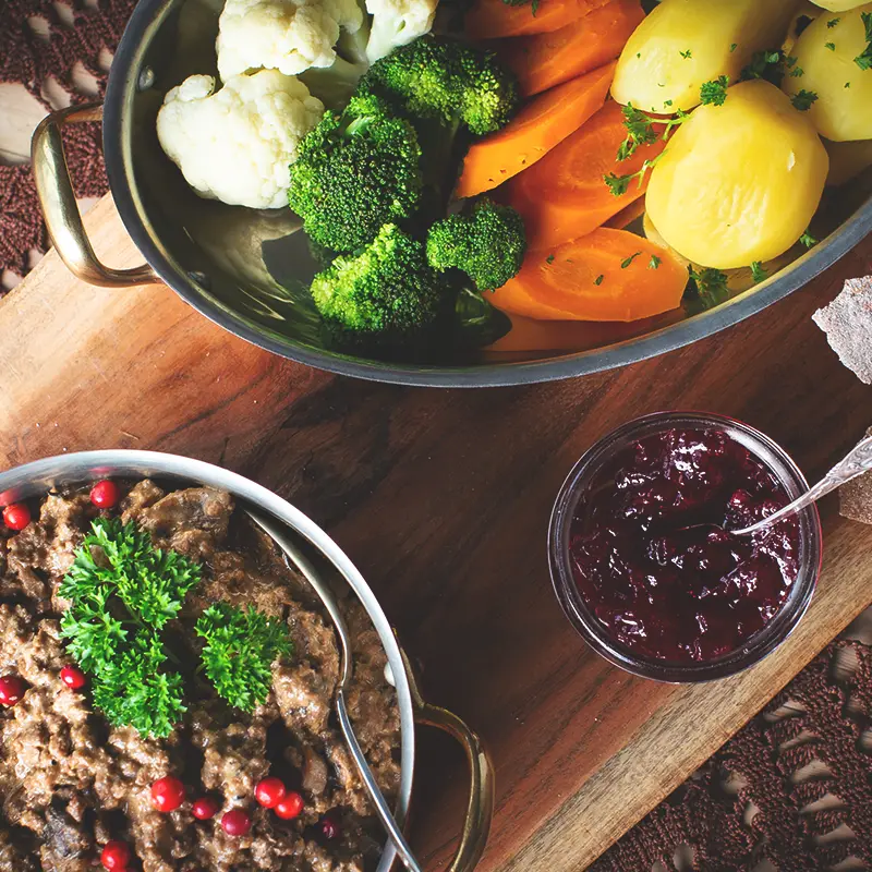 A bowl of food on a wooden surface at a catering event.